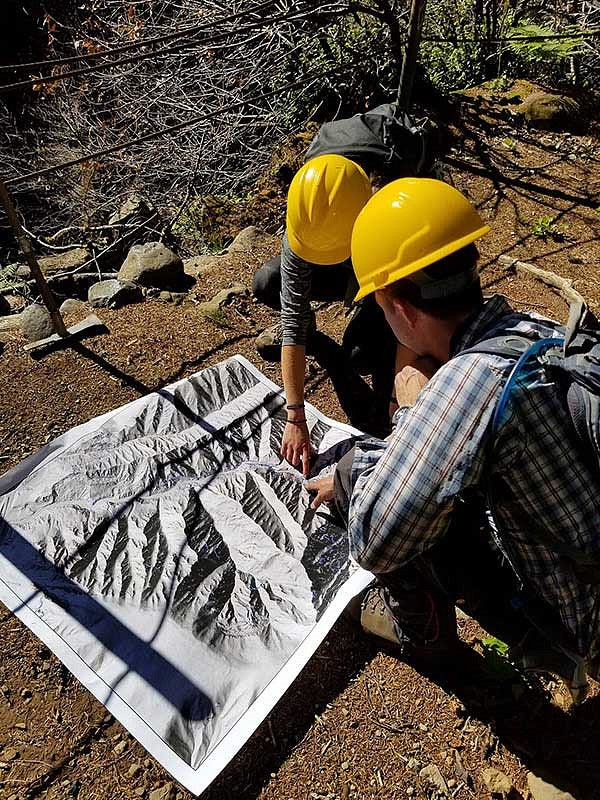 Two people looking over an aerial photo of Eagle Creek area