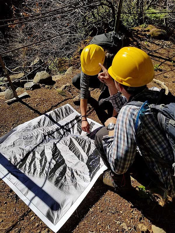 Two people looking over an aerial photo of Eagle Creek area