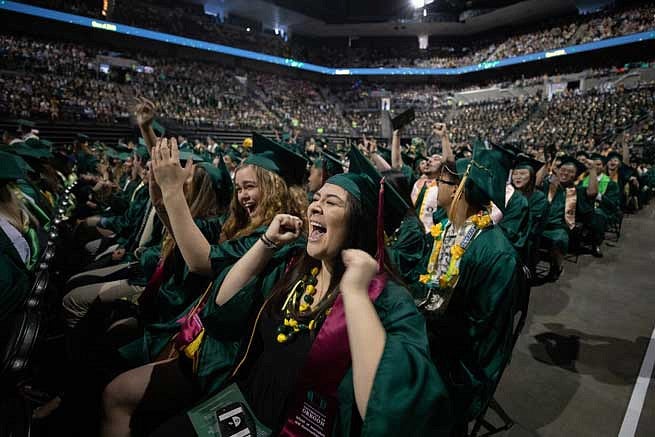 Graduates cheering during the commencement ceremony Graduates cheering during the commencement ceremony