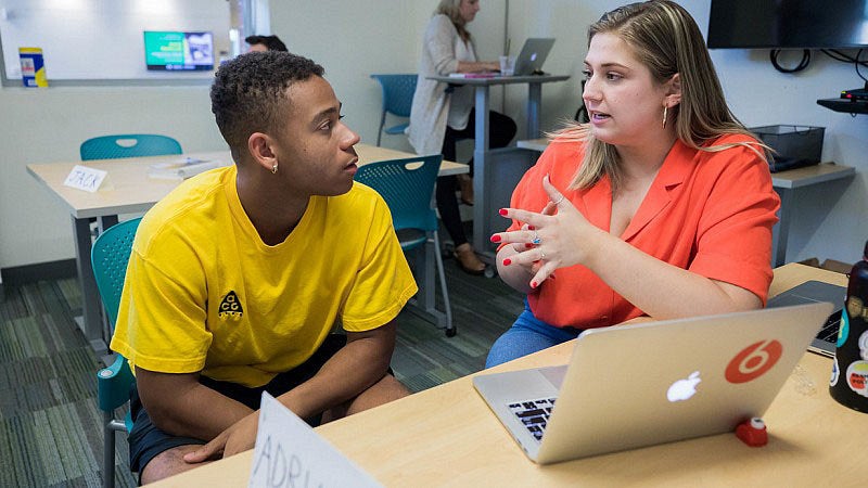 Two students having a discussion while studying