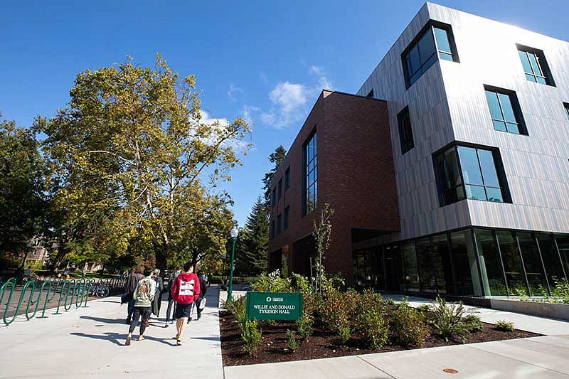 Students walking on the sidewalk next to Tykeson Hall