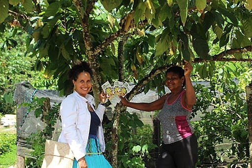 two women standing in the shade below a tree