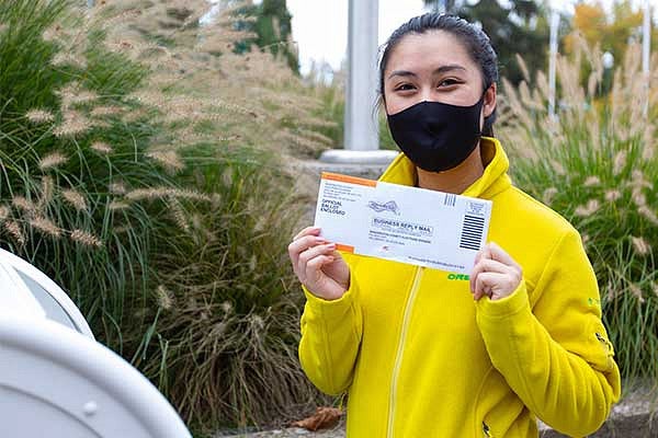 A student holding their ballot that's ready to be dropped off