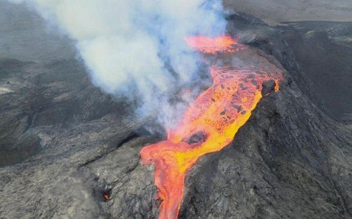 The volcano pours lava out of the caldera