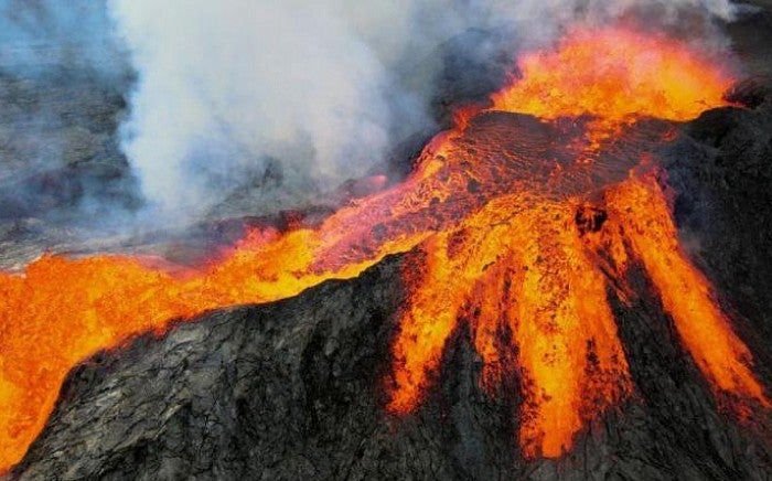 Volcano fully erupting with large flows of lava