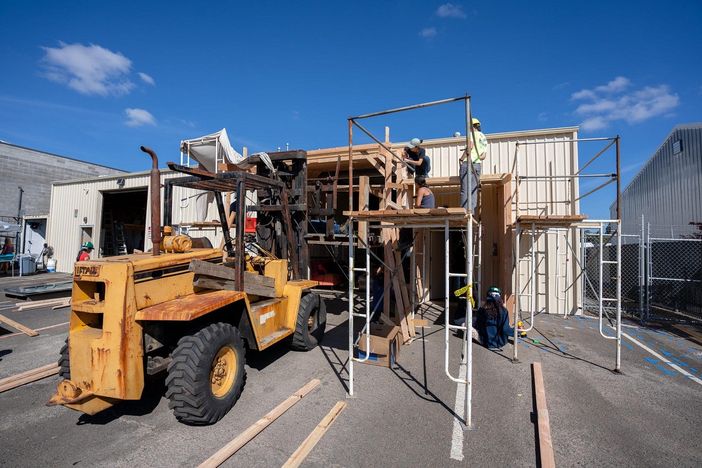 A fork lift next to scaffolding outside the construction site during the Bruton Design Intensive