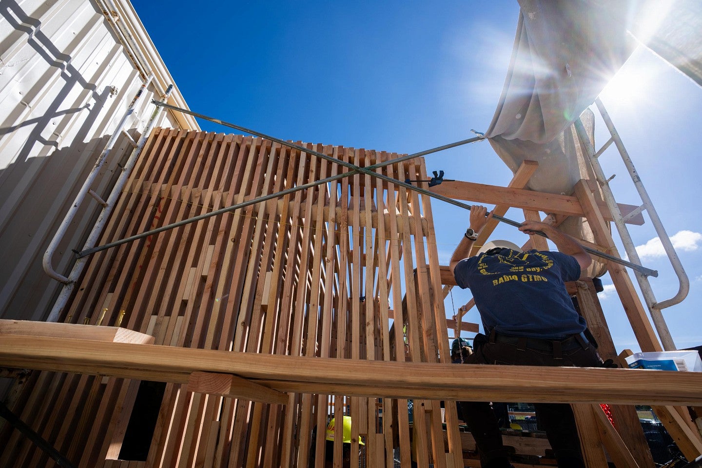 A student standing on a scaffold during construction of a home during the Bruton Design Intensive