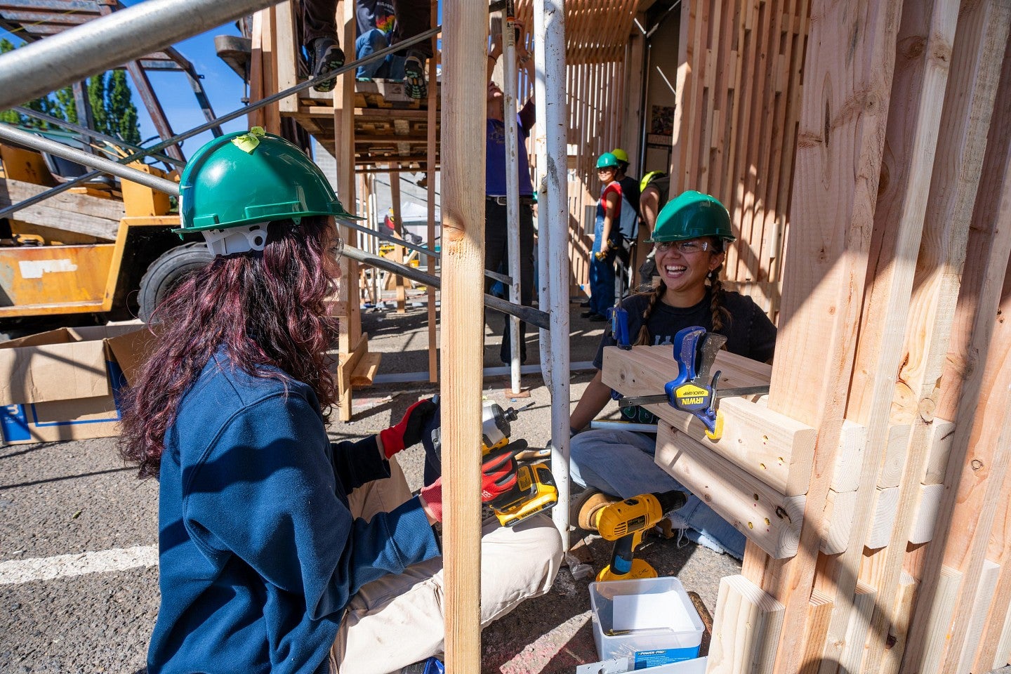 Two students working with power tools while building the new home during the Bruton Design Intensive