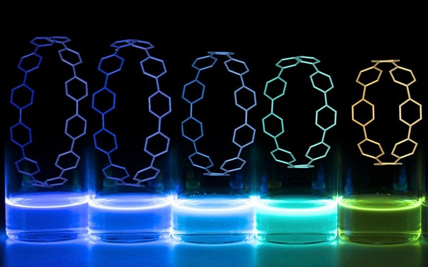 A row of vials with glowing liquid in different colors