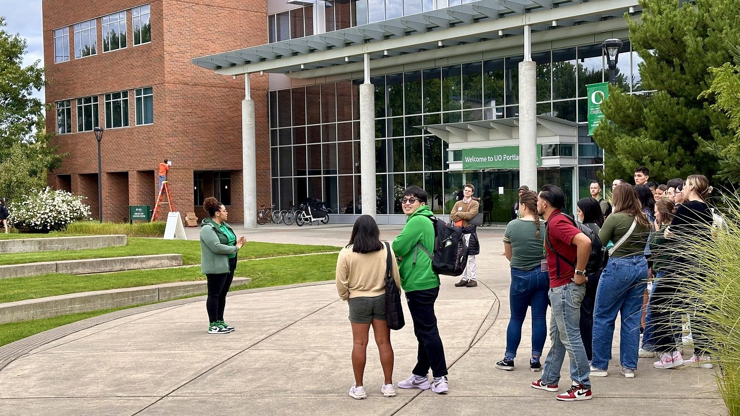 A group of UO Portland students gather outside a building to listen to their tour guide
