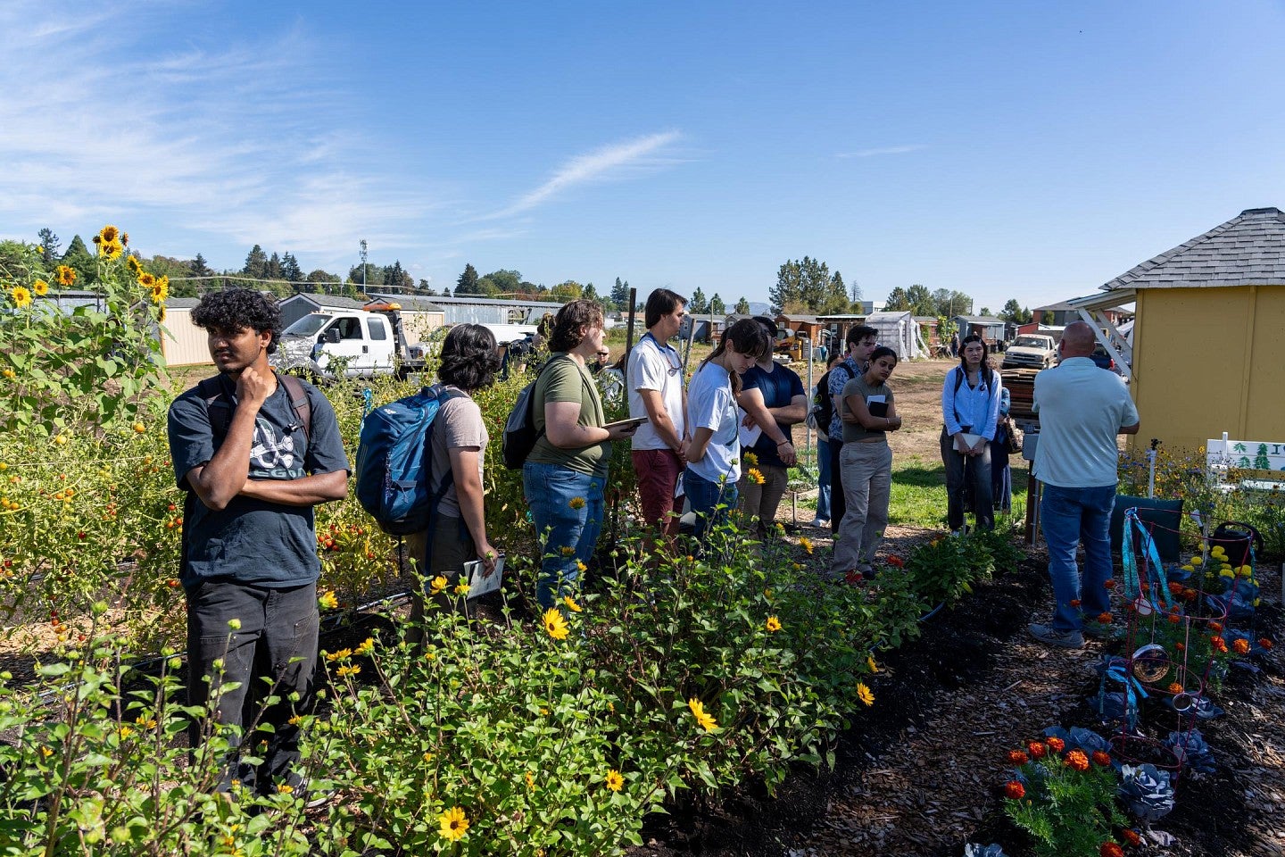 Students standing in the garden during a tour of "Everyone Village" during the Bruton Design Intensive