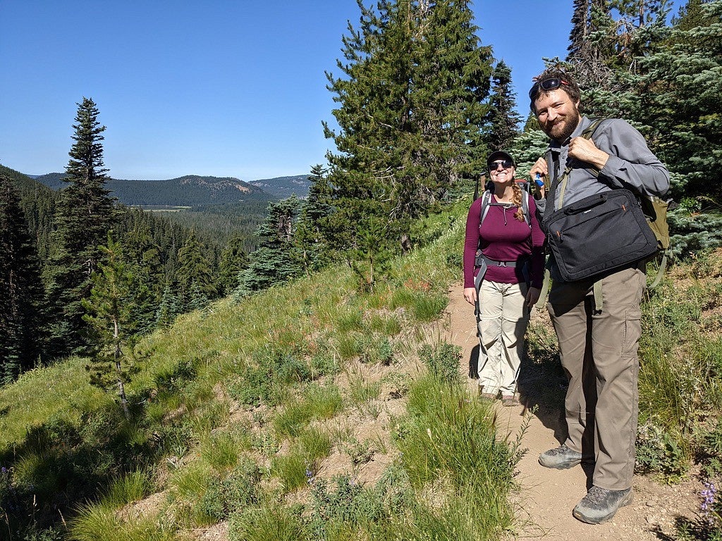 Annika Dechert and Joe Dufek in an evergreen forest while collecting rock samples.