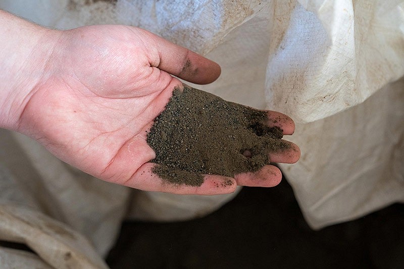 a hand holding basalt dust