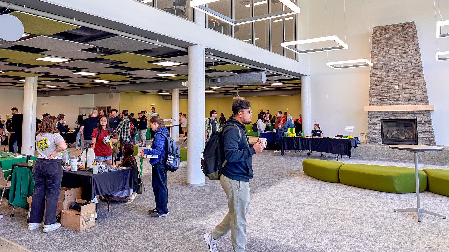 UO students talking to representatives and walking through a campus building at the UO Portland resource fair