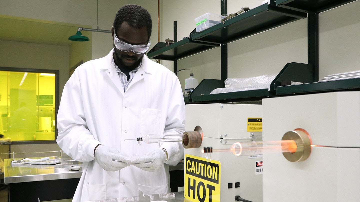 Man in lab coat working in a UO lab