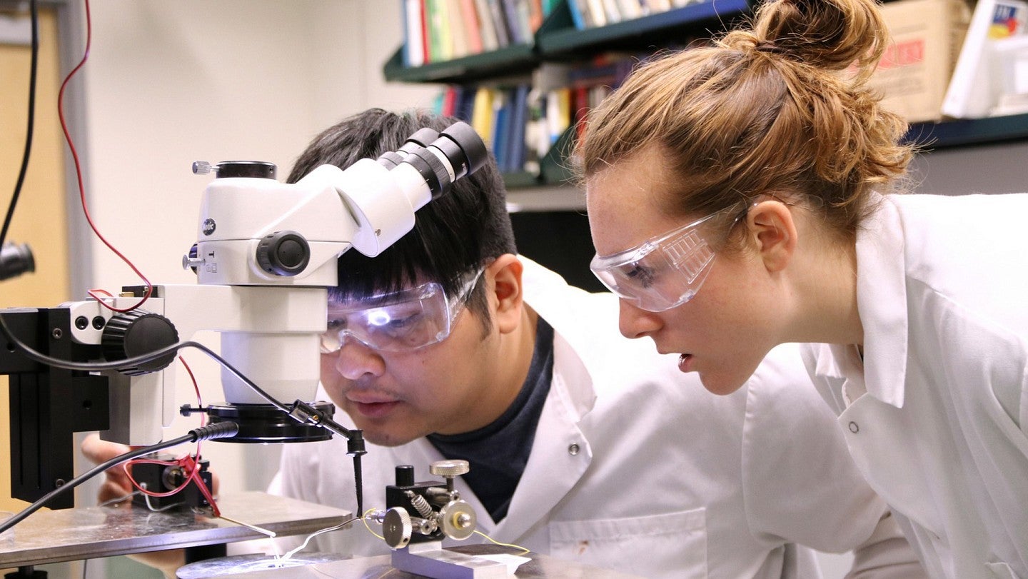 Researchers setting up electron microscope