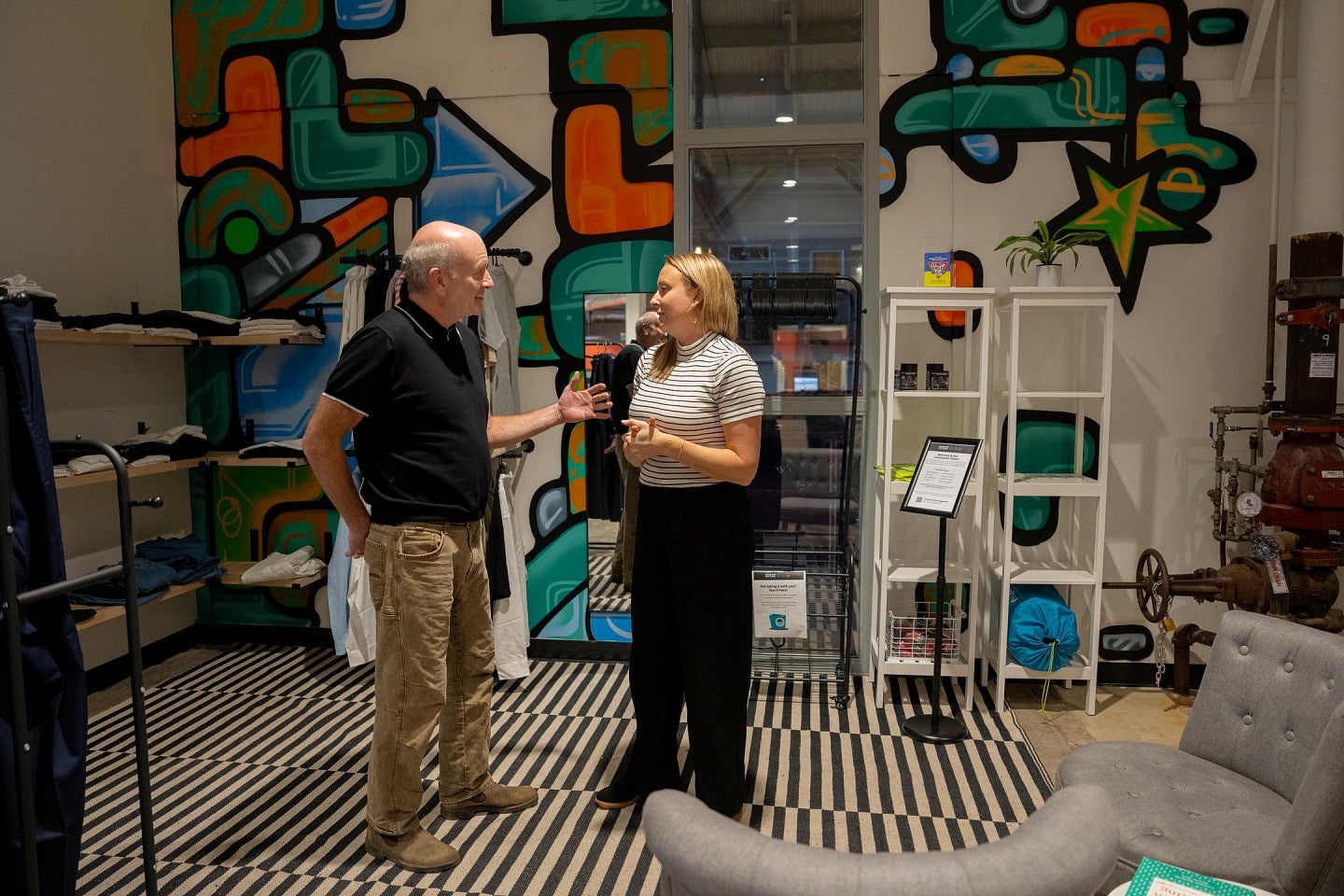 A man and a woman talk in the colorful space of a nonprofit that serves youth.