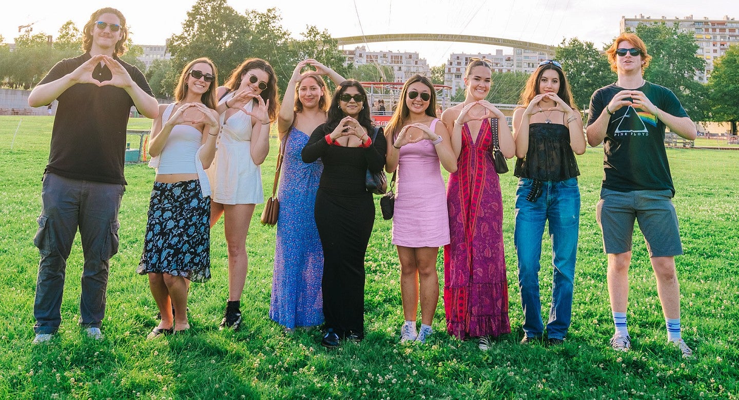 Study abroad students throwing the O in a Paris park