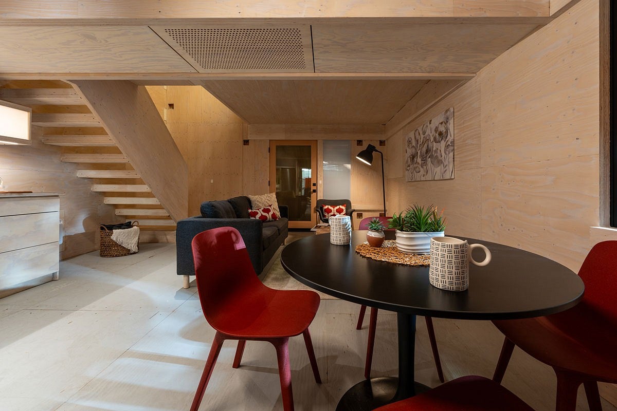 a kitchen table and sofa inside a prototype mass plywood home