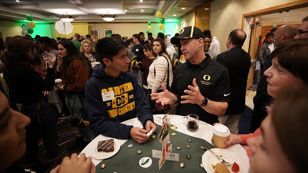 Male teenager talking to Robert Guldberg of the Knight Campus at a recruitment event