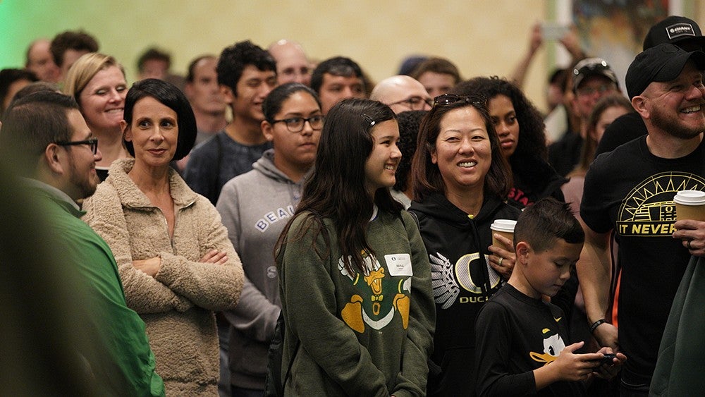 A female potential student with her parents in a crowd at a recruitment event