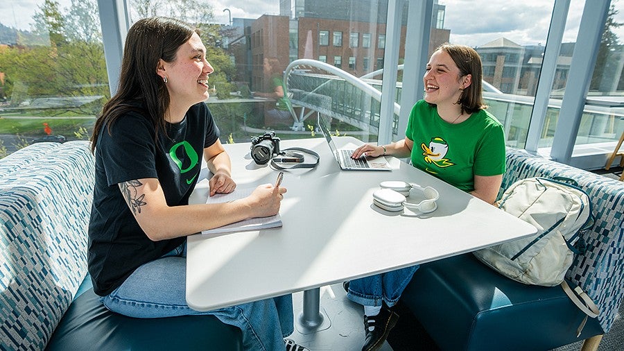 Two female students sitting and chatting at a table