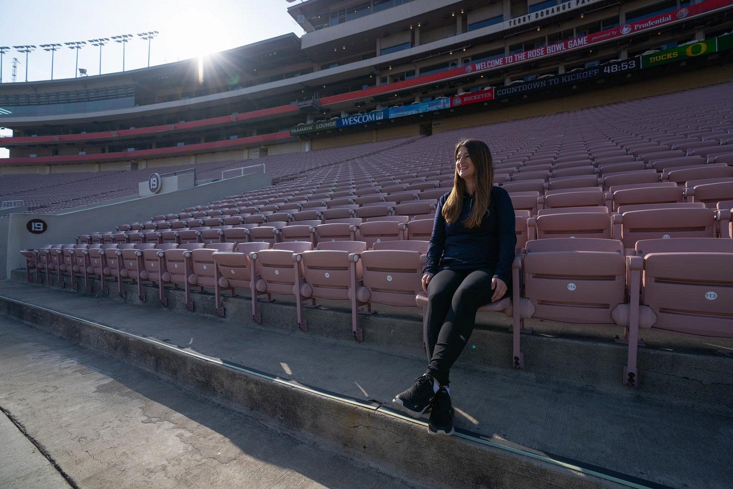 Julia Goldstein sitting in the empty stands at Rose Bowl Stadium