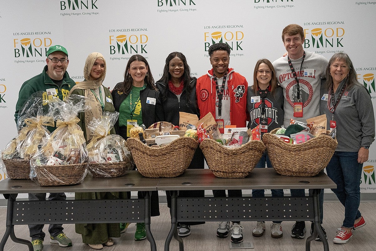 Representatives from UO and Ohio State pose for a photo after exchanging gift baskets.