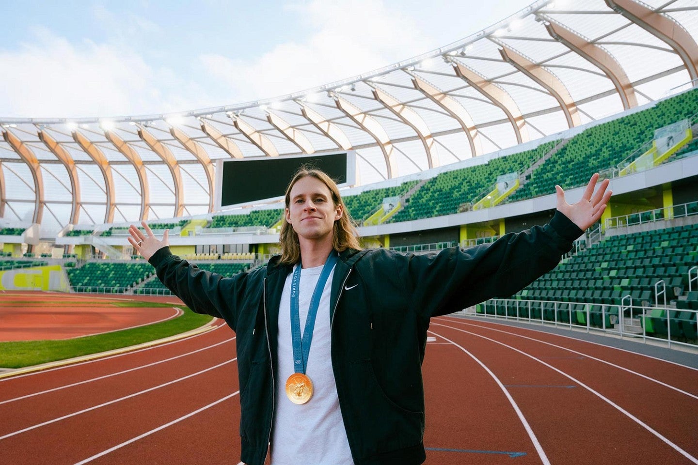 Cole Hocker wears his Olympic gold medal on the track at Hayward Field