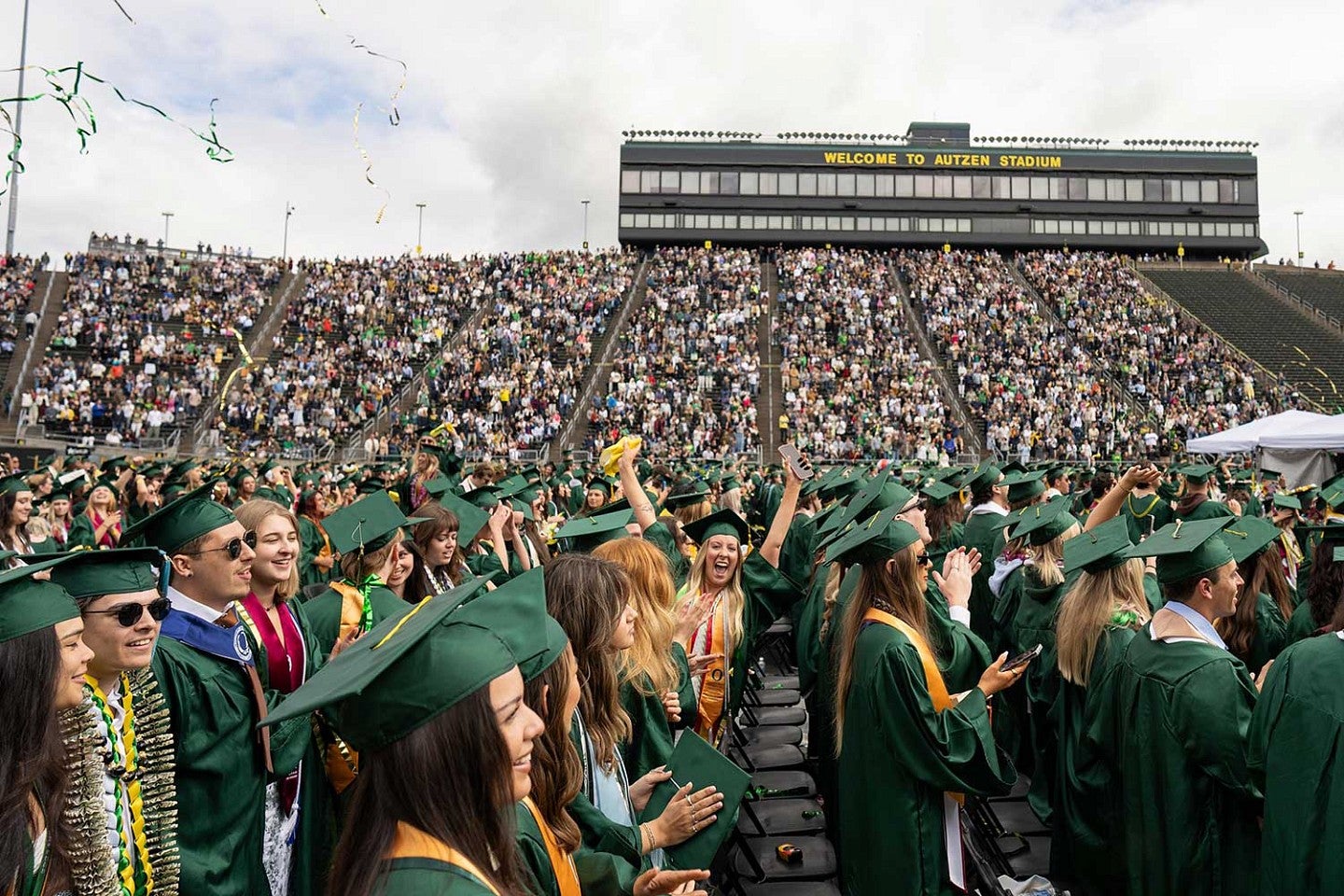 students celebrate during commencement inside Autzen Stadium 