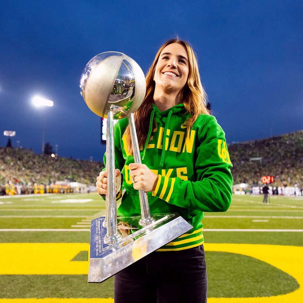 Sabrina Ionescu holding the WNBA Championship trophy in front of stadium crowd