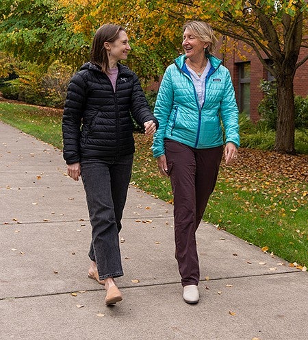 Kate Hails and Beth Stormshak walking on campus