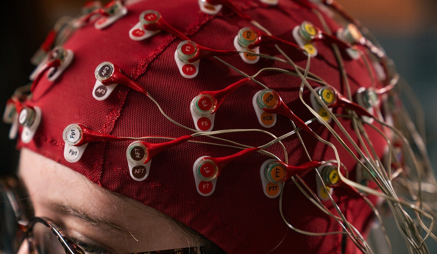 Woman in lab with electrodes attached to a cap over her head