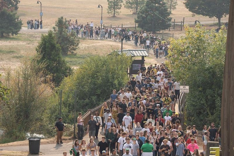students on the walking path making their way from the Eugene campus to Autzen Stadium