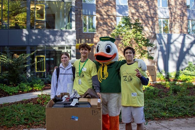 Duck posing with student and volunteers at Unpack the Quack