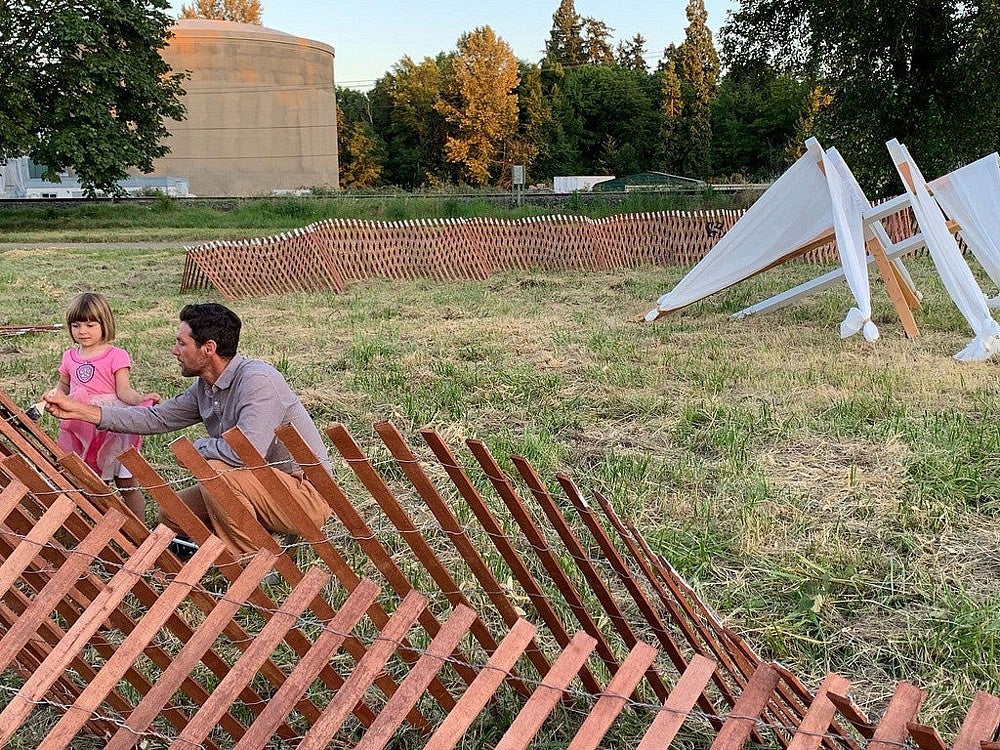 Michael Geffel paints a fence