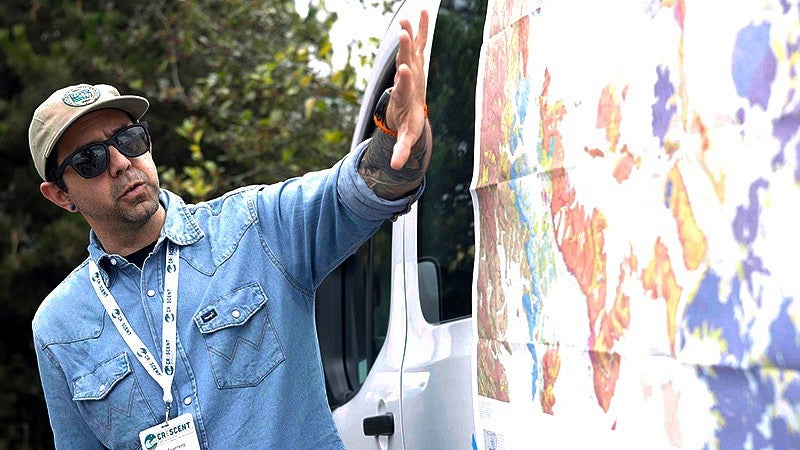 Lalo Guerrero gestures to a geological map