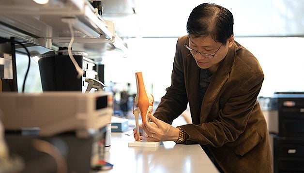 Penderia Technologies co-founder Keat "Ghee" Ong positions a sensor on a model of a knee joint.