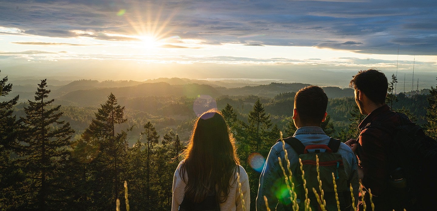three people watching the sunset from Spencer Butte in Eugene