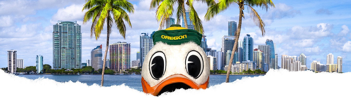 The Oregon Duck in front of a photo of Miami