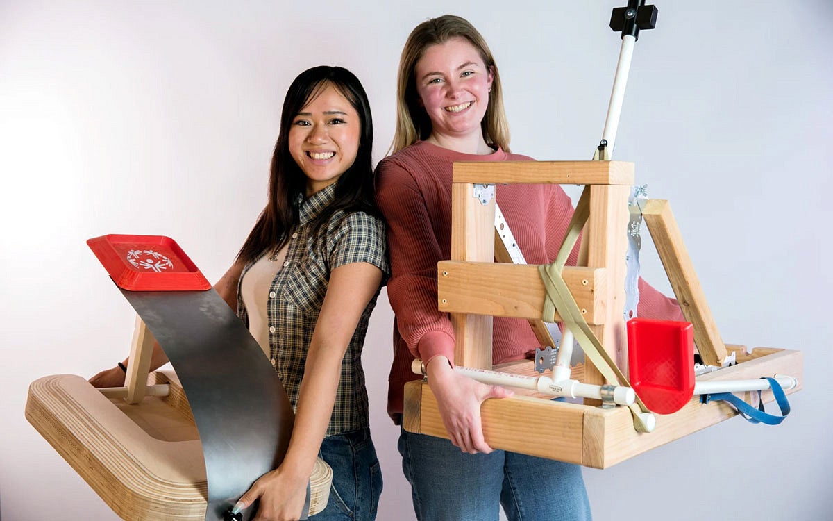 Morgan Nguyen and Kailey Chaffee hold devices they designed to help Special Olympians compete