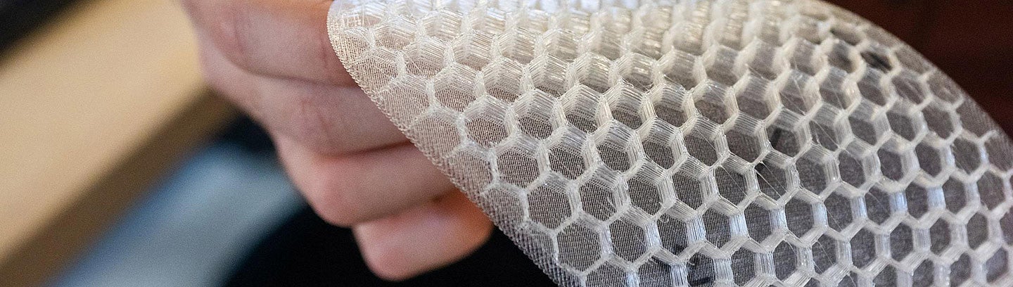 a person holds a flexible honeycomb-like material
