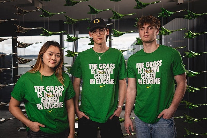 Three people wearing shirts with the words "The Grass is Damn Green in Eugene"