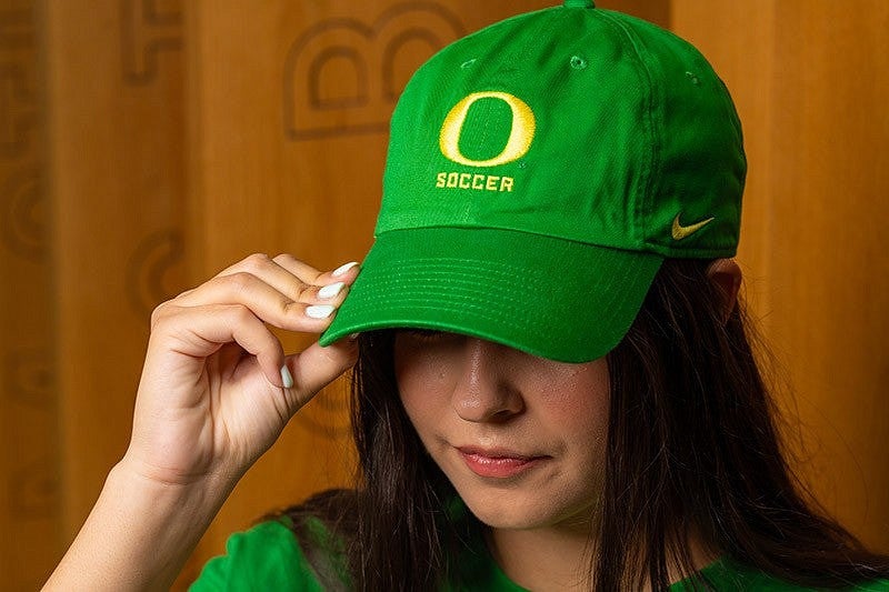 Person wearing a green UO Soccer hat