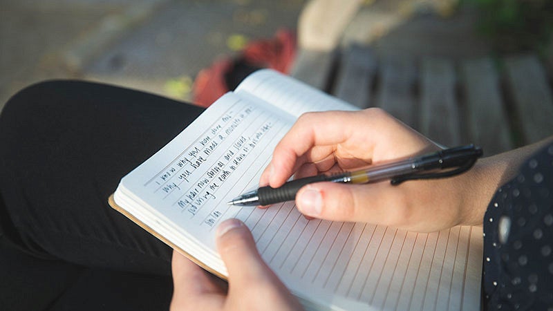 Andi Butts writing in a journal