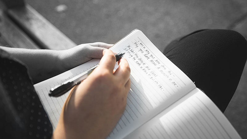 Andi Butts writing in a journal