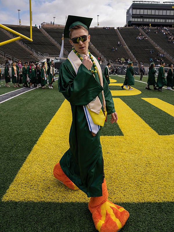 Student wearing The Duck feet at the 2022 UO graduation at Autzen Stadium