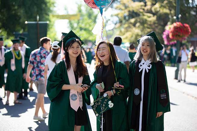 Three female graduates during the Duck Grad Parade Three female graduates during the Duck Grad Parade