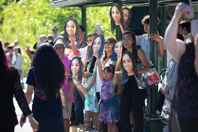 Friends and family holding cardboard cutouts of a graduate's face Friends and family holding cardboard cutouts of a graduate's face