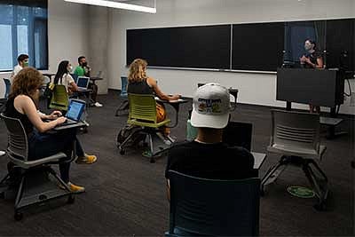 Students in a classroom wearing masks while sitting physically distanced